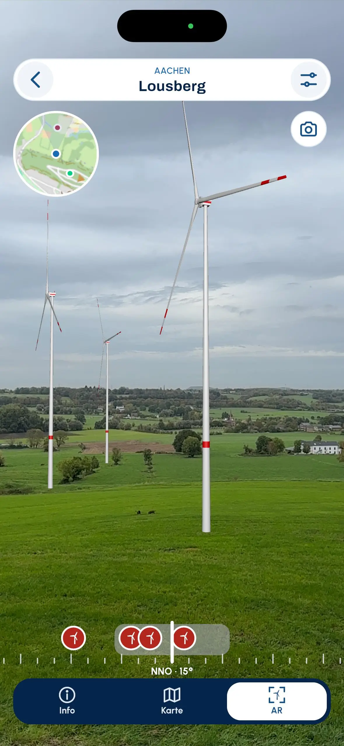 AR-Ansicht: geplante Windturbinen stehen maßstabsgetreu in der realen Landschaft, mit Minikarte und Kompass